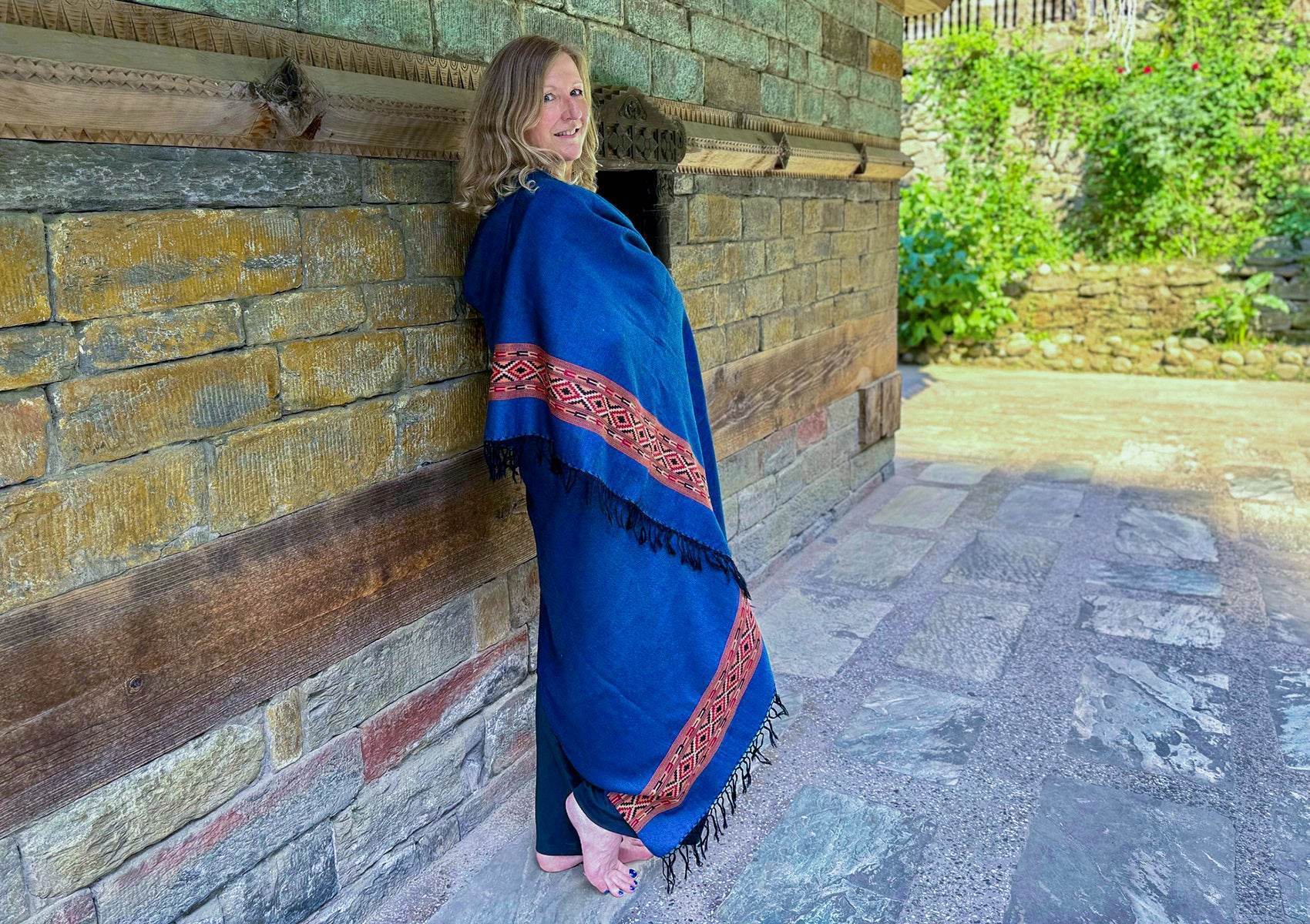 Élégant châle DEVA bleu royal en pure laine mérinos, drapé autour d’une femme dans la cour d’un temple