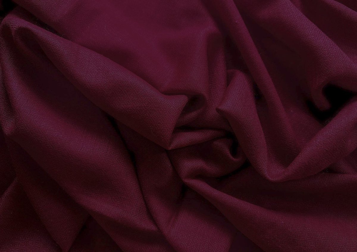 Close-up of a handwoven burgundy pashmina meditation shawl featuring delicate fringes and a soft diamond weave texture.