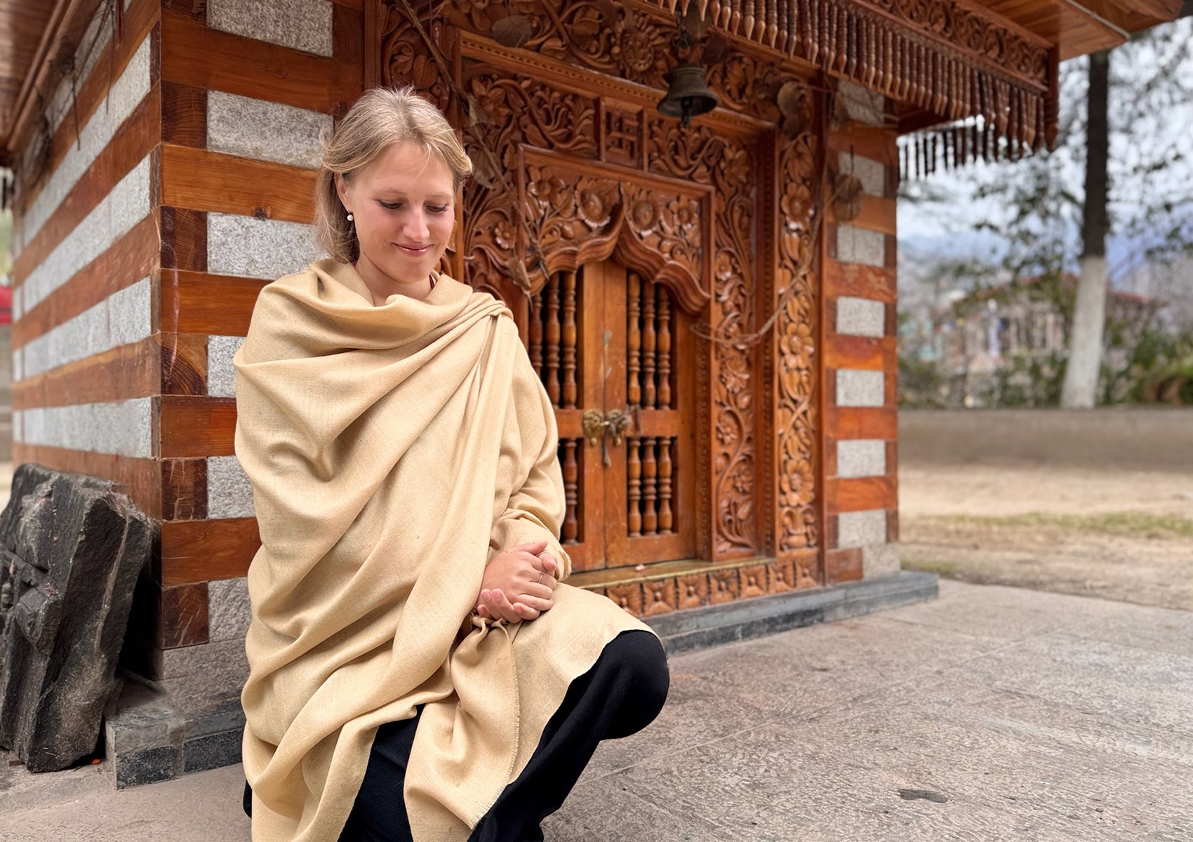 Lightweight Shunyata wool-silk shawl in beige with sacred temple background