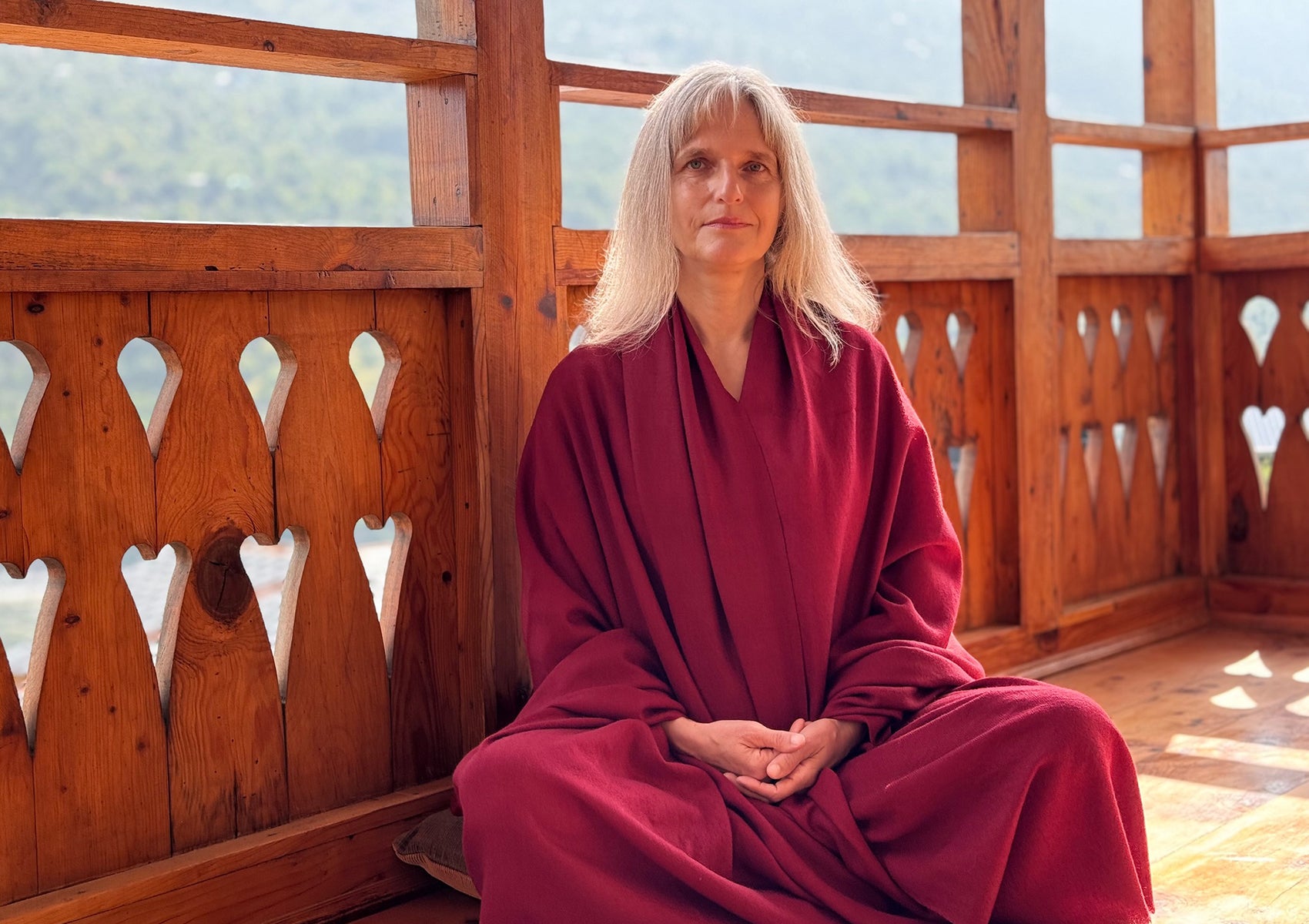 Meditator in lotus position wearing a LAMA burgundy Tibetan meditation blanket, perfect for Vipassana practice.