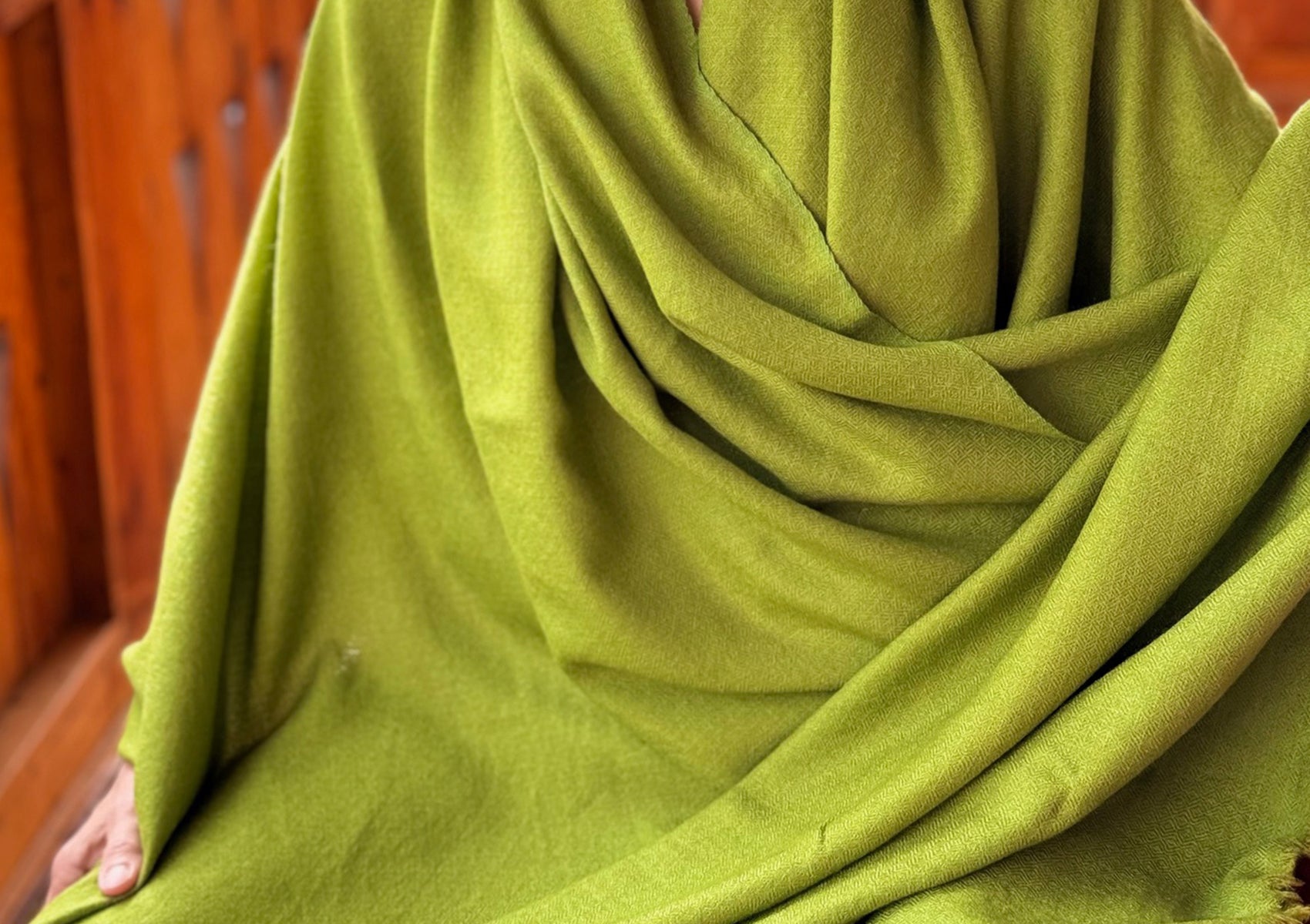 Close-up of Lama Green meditation shawl in soft merino wool, showing fine twill weave and vibrant green color.