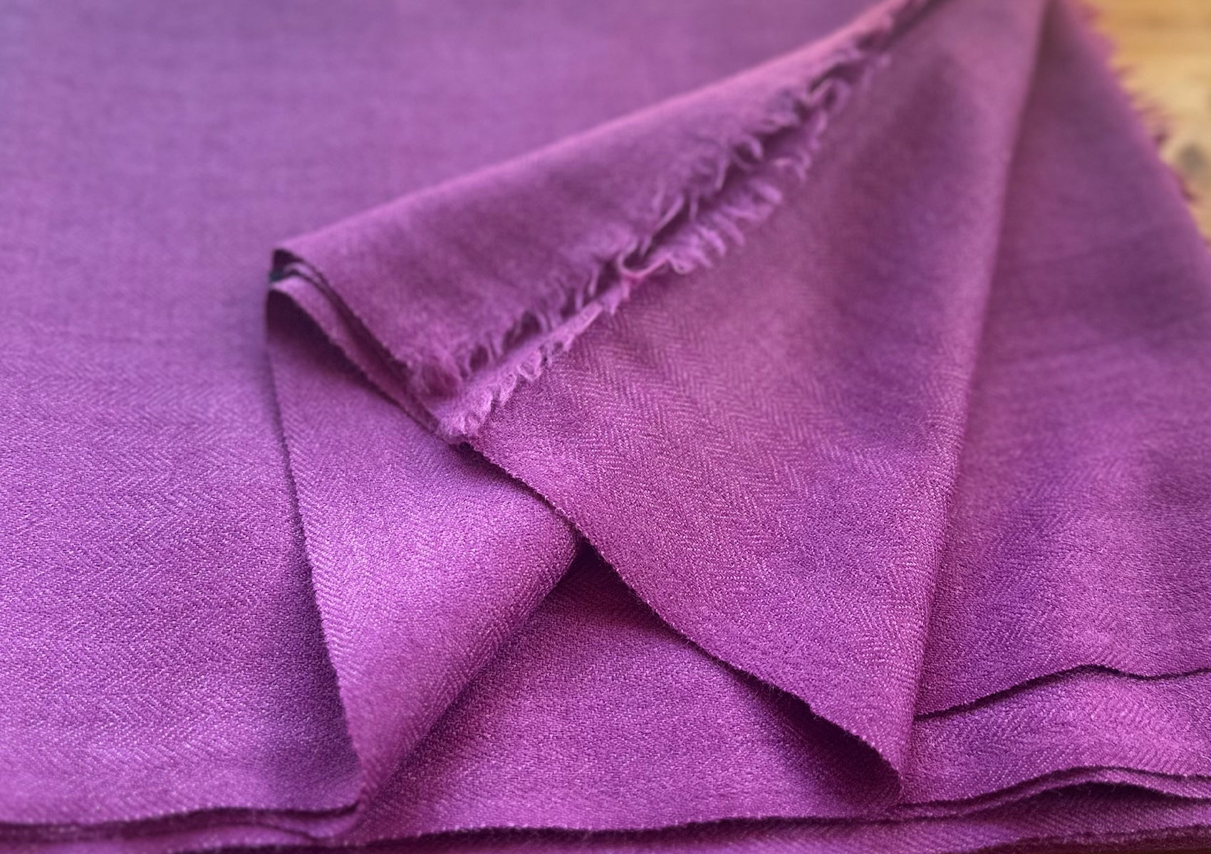 Close-up of handwoven merino wool LAMA shawl in light purple.