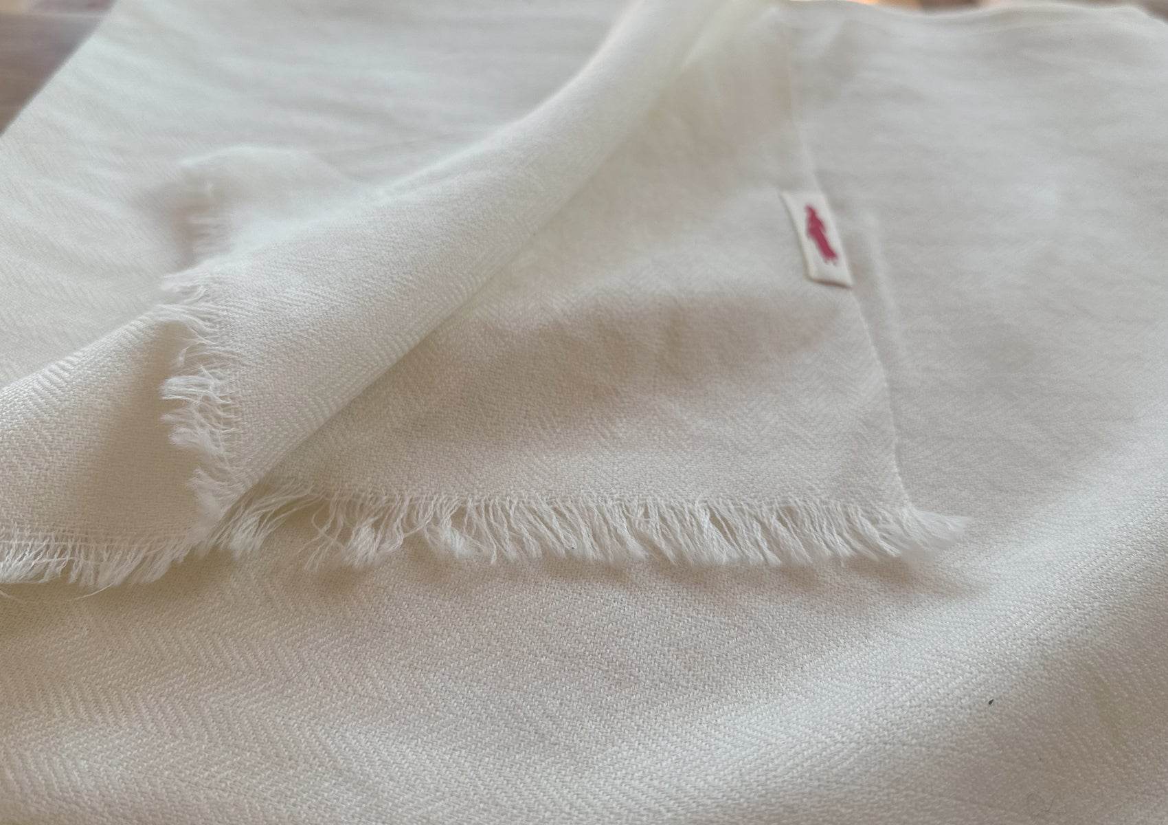 Detailed texture view of handwoven cream Tibetan lama shawl, highlighting soft wool and artisanal craftsmanship.