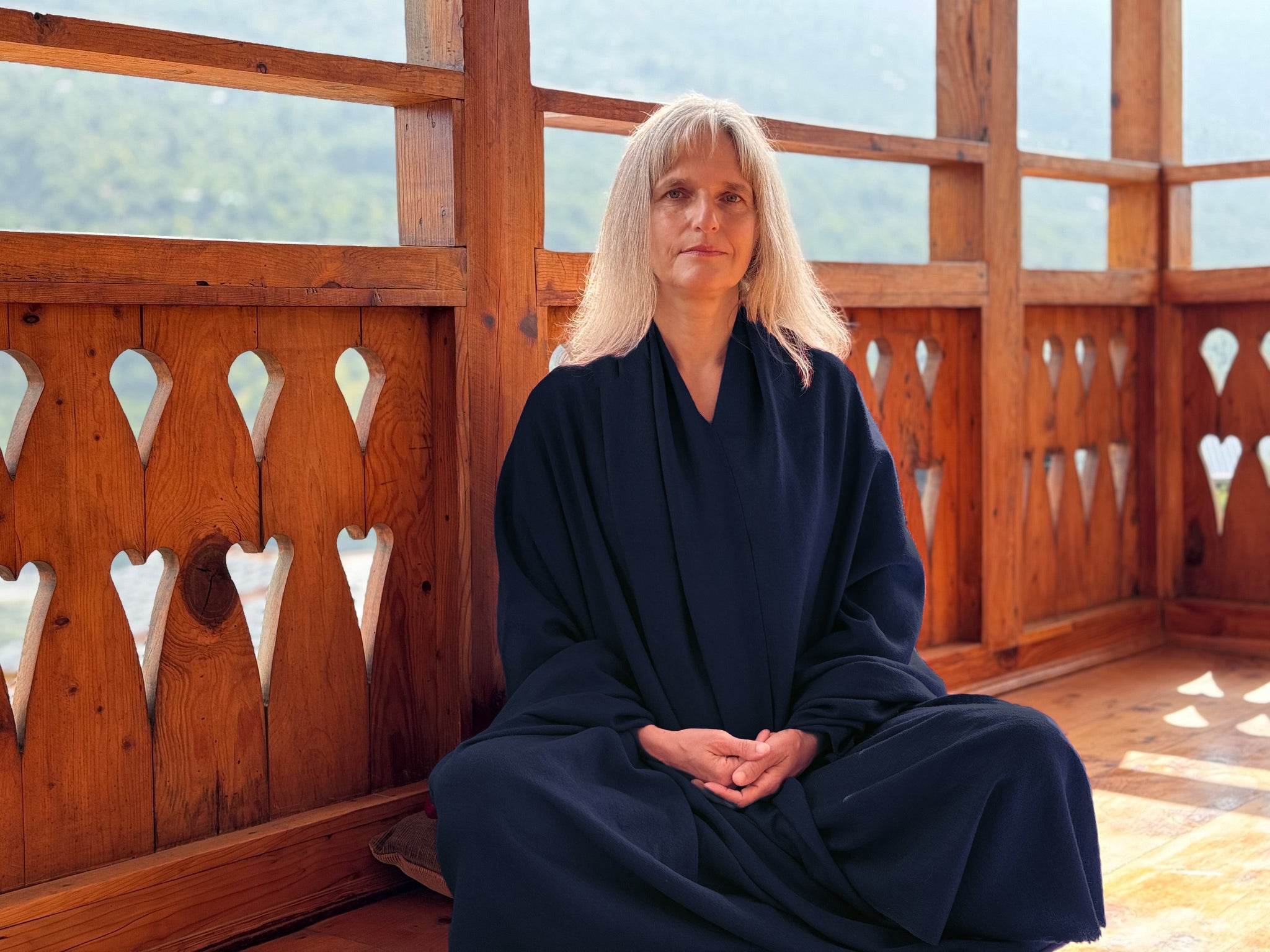 Woman meditating wrapped in the Lama navy blue large meditation blanket.