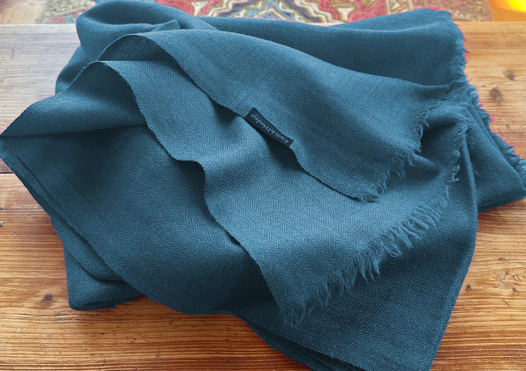 Close-up of the LAMA steel blue shawl showing fine herringbone texture.