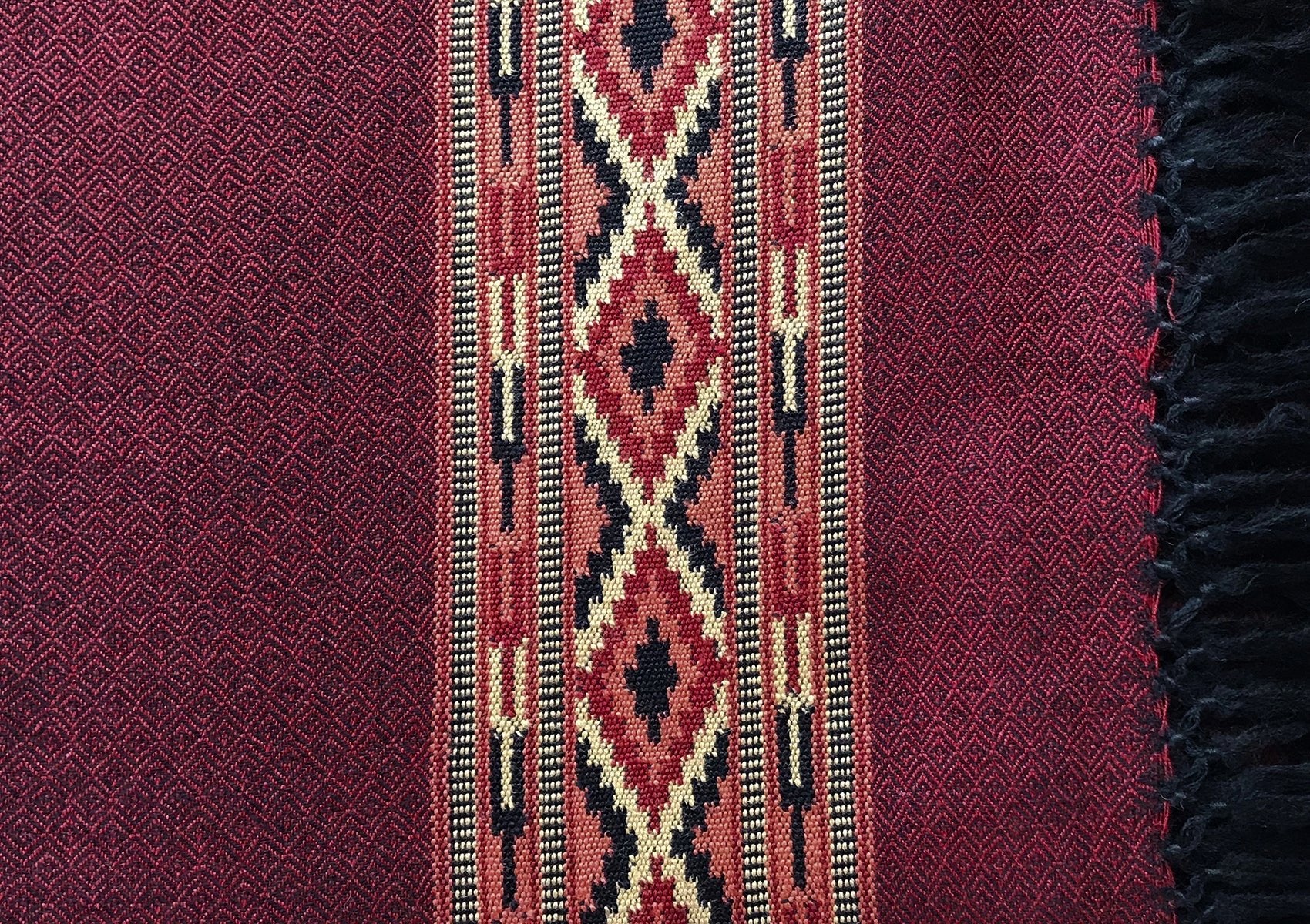 Detailed view of DEVA dark red merino wool meditation shawl showing traditional woven ethnic border.