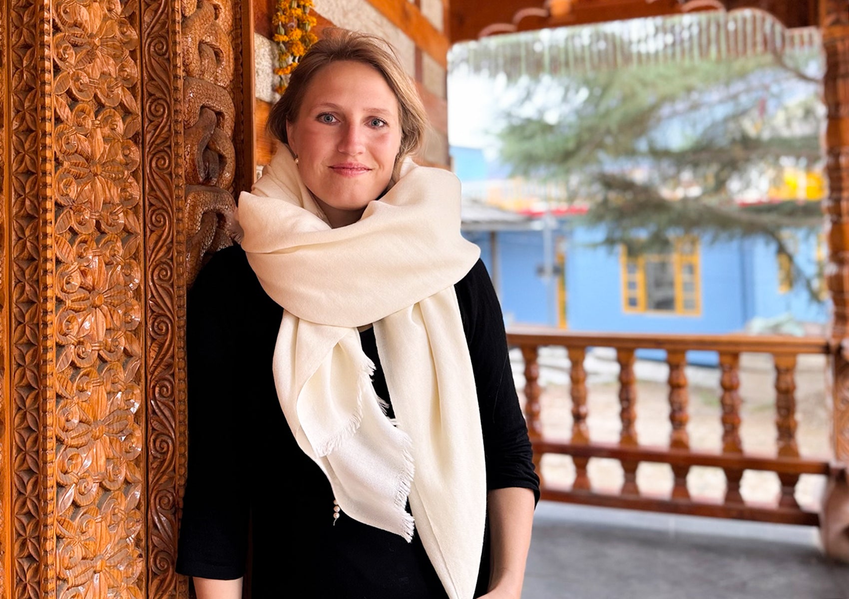 Close-up portrait with the cream LAMA shawl wrapped softly around the neck