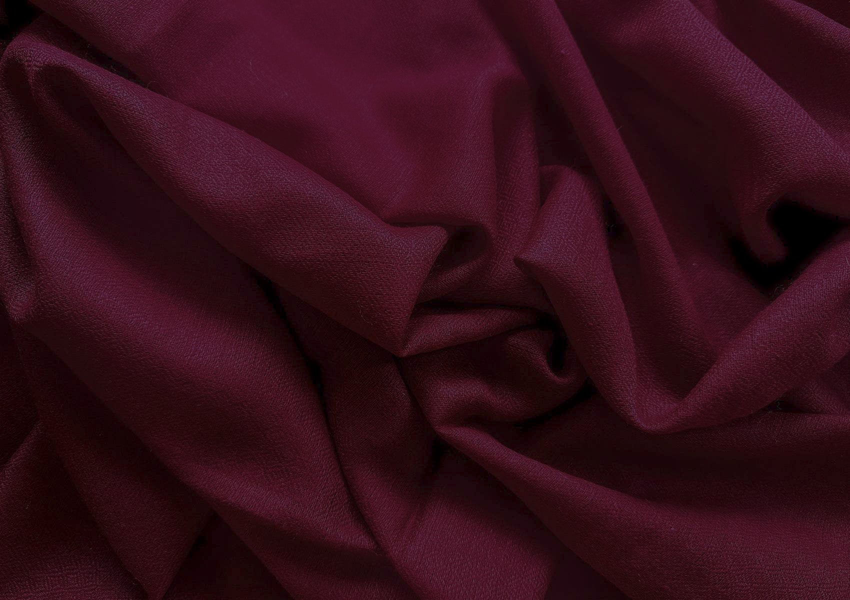 Close-up of a handwoven burgundy pashmina meditation shawl featuring delicate fringes and a soft diamond weave texture.