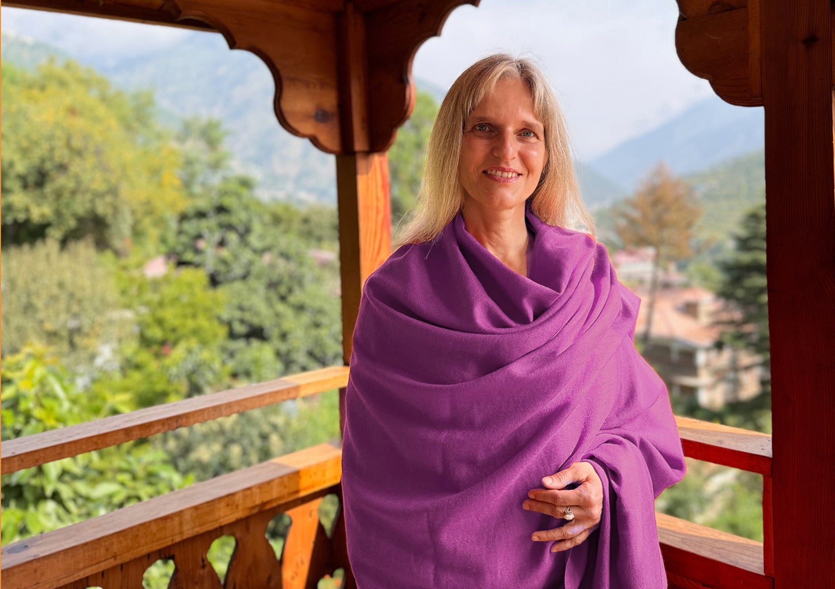Woman standing at Himalayan temple wearing LAMA light purple meditation shawl.