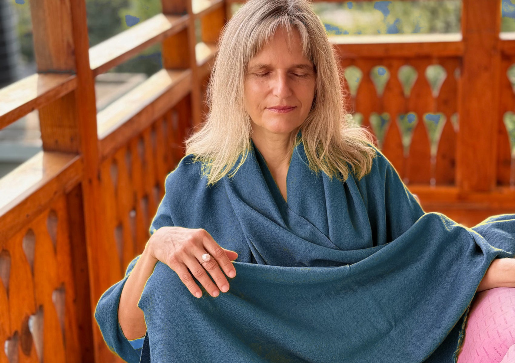 Large LAMA steel blue meditation wrap covering a seated woman in meditation posture.