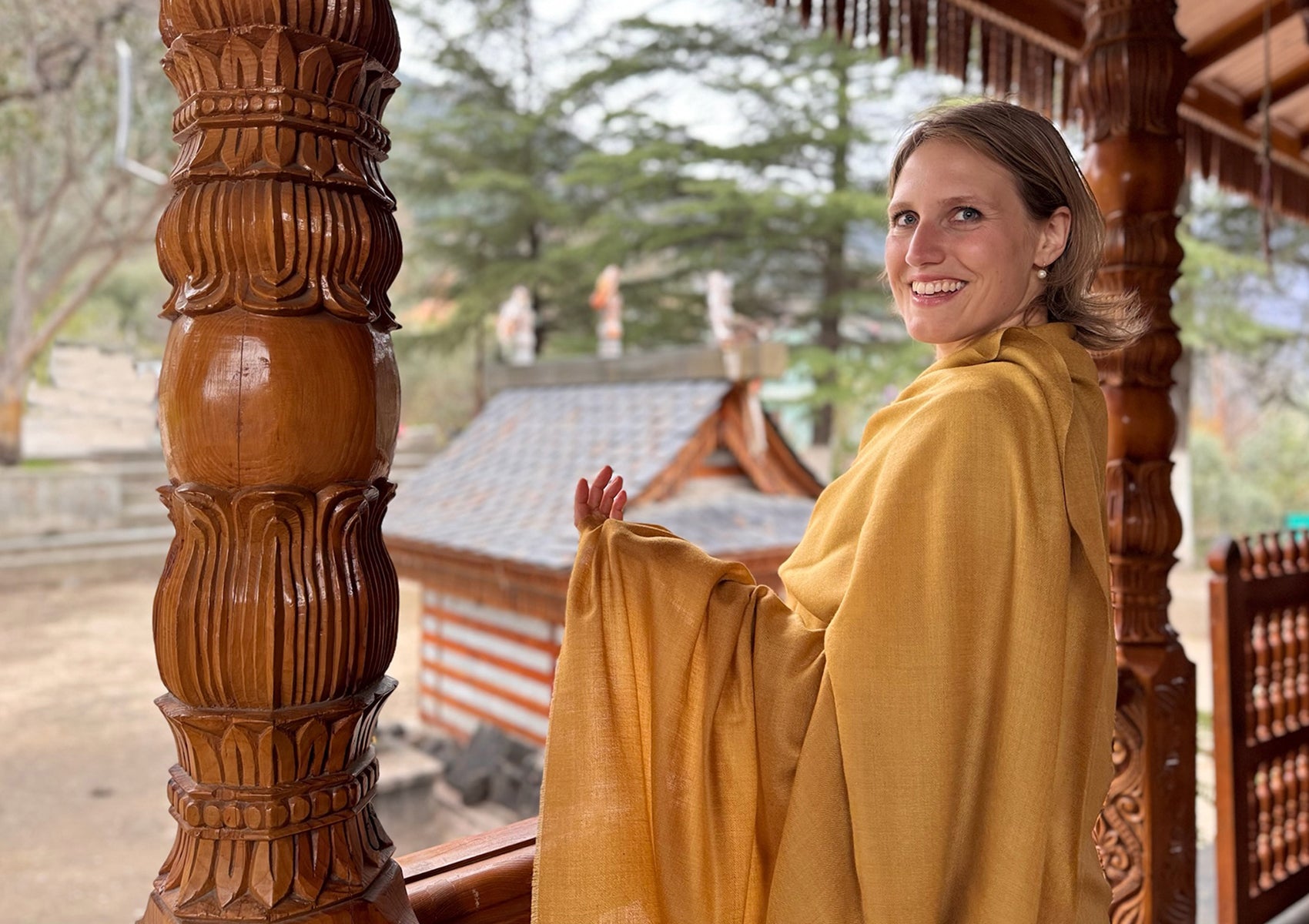 Shunyata ocher shawl with visible fold detail – elegant drape in front of temple