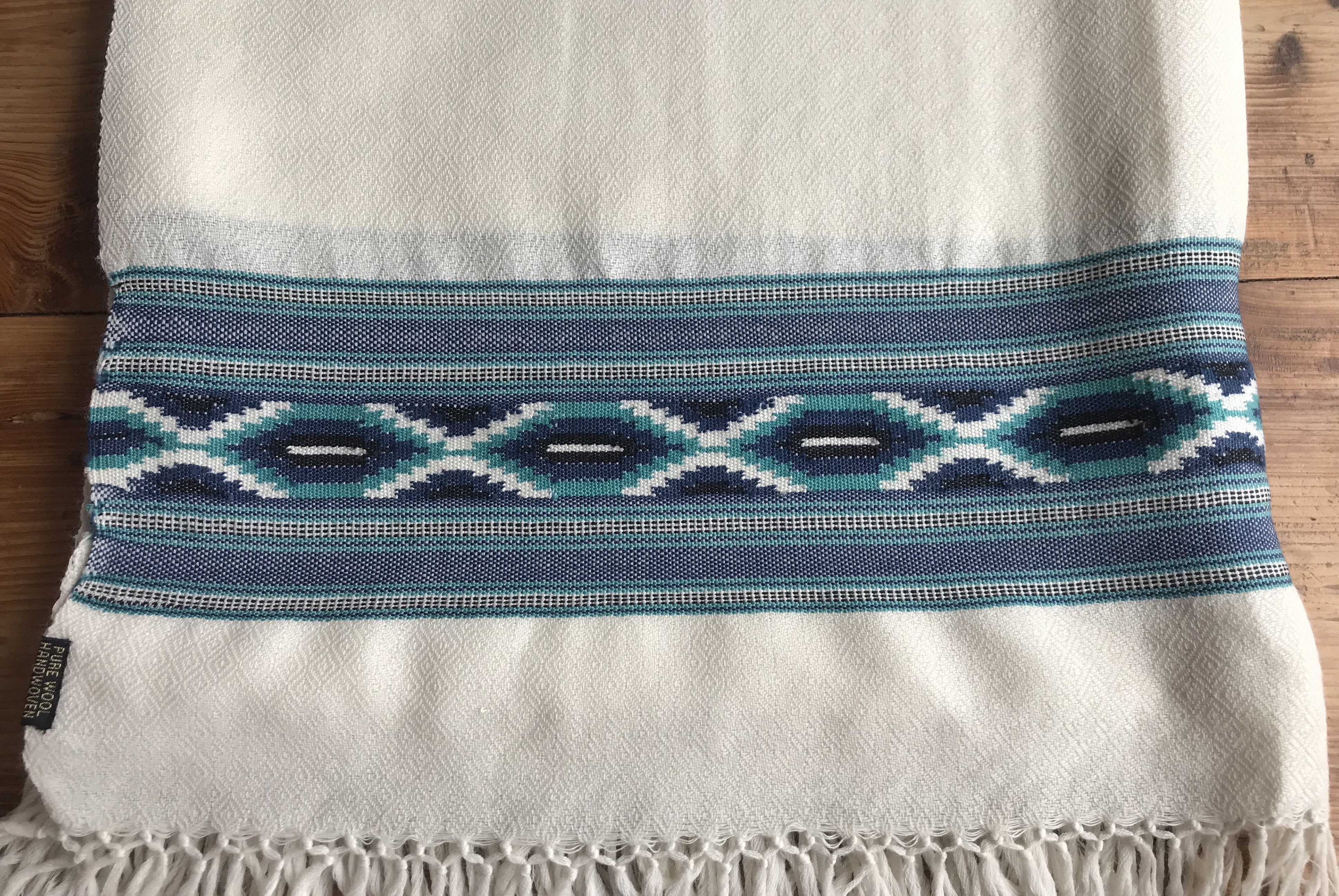 Blue and cream meditation shawl draped over surface, showcasing cultural patterns and suitable for cozy retreats.